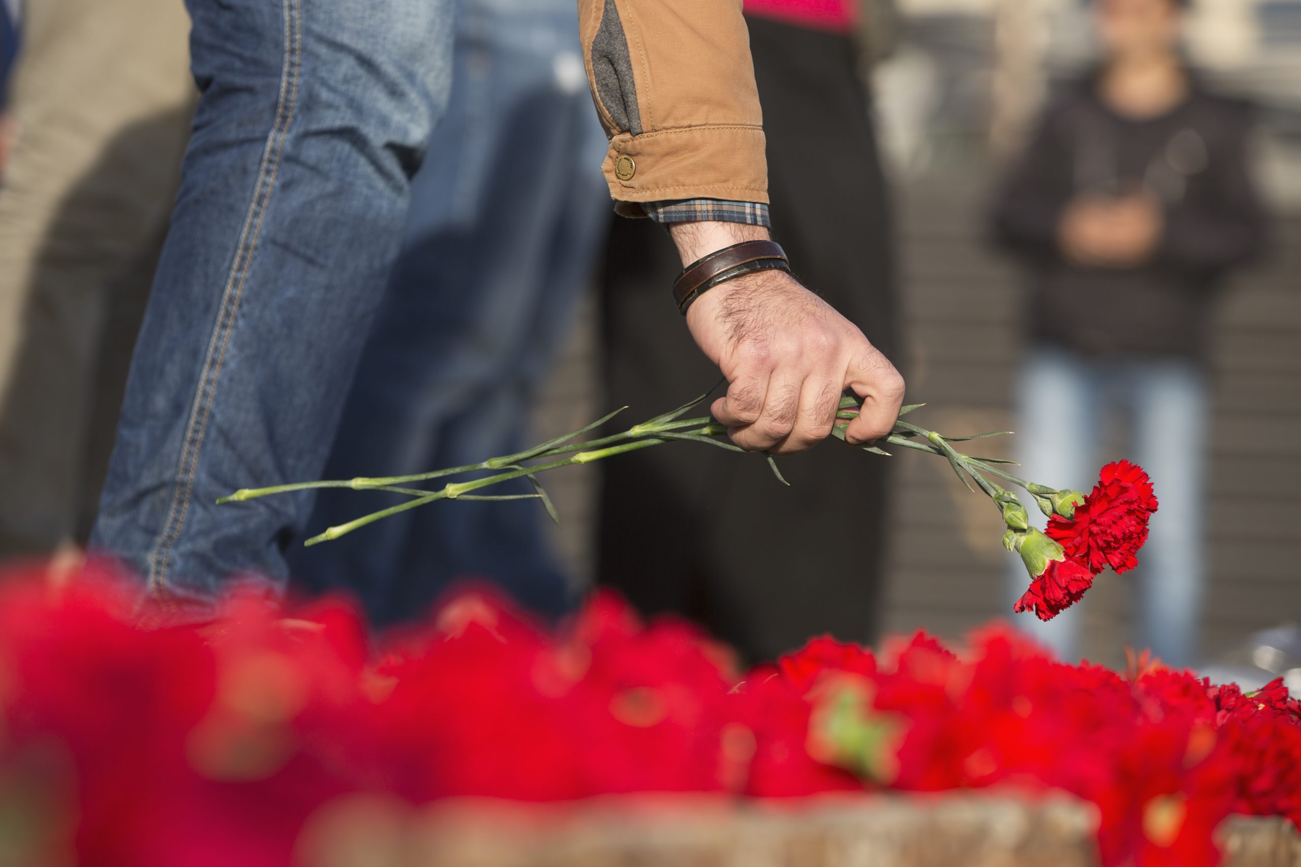 Man Leaves a Flower on a Memorial